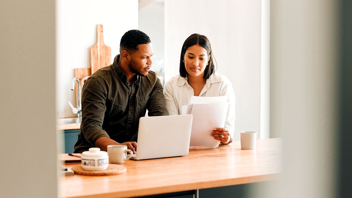 couple-with-laptop-looking-at-document-paper-work